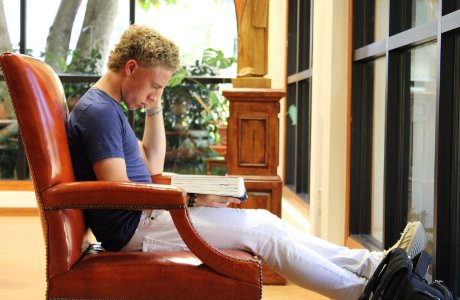 Student reading in a chair in the library