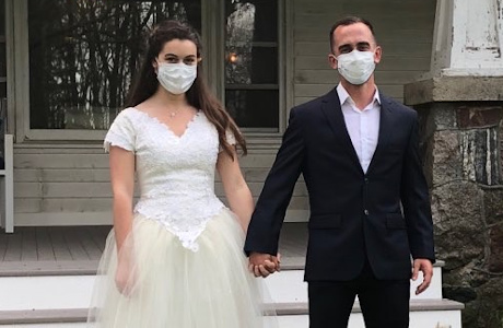 Mr. and Mrs. Nazeck in wedding clothes and medical masks
