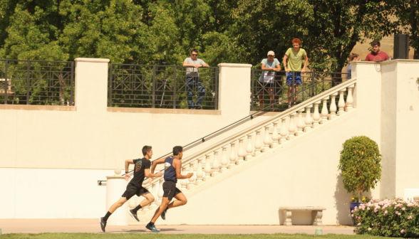 Two students sprinting by the stairs to St. Joseph's Commons