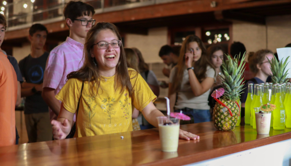 A student smiles for the camera at the drink counter