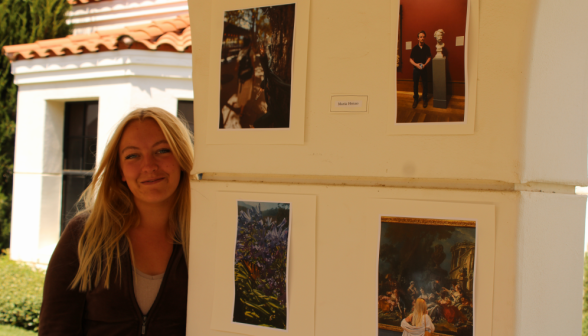 A student beside four of their photographs
