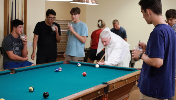 Fr. Walshe lines up a shot in pool