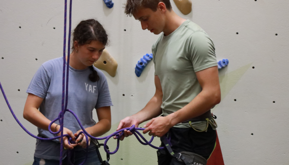 Two attach safety equipment for rock climbing
