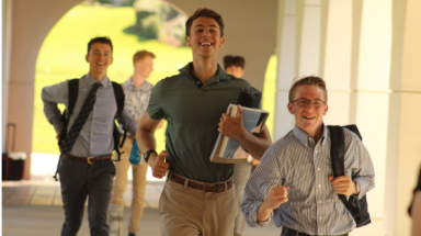Students running alongside academic quadrangle