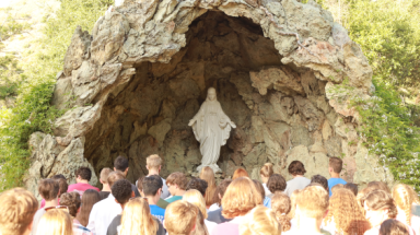 Students praying at Lourdes Grotto