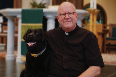 Bishop Byrne with his black Labrador retriever, Zelie.