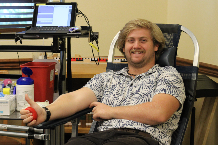 A student, about to have blood drawn, gives the thumbs-up
