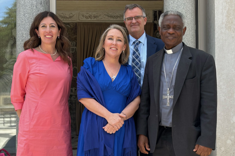 Caption: Dr. Pia de Solenni (’93), senior director of corporate engagement for IWP Capital, with IWP CEO Sam Saladino, his wife, Cara, and His Eminence Peter Cardinal Turkson, Chancellor of the Pontifical Academy of Sciences