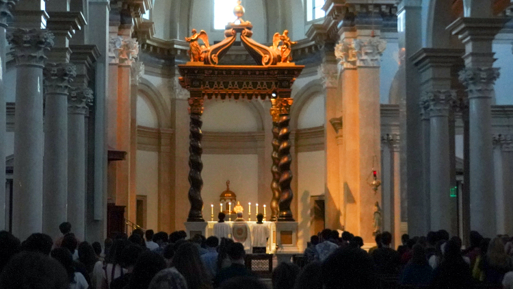 The Chapel in darkness, with students adoring the exposed Blessed Sacrament