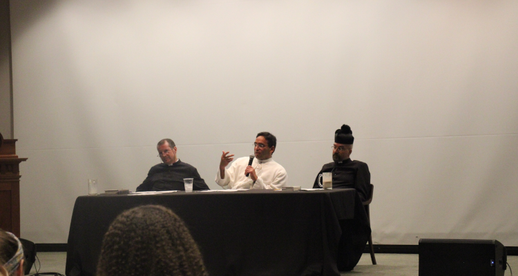 The three priests answer theology questions at a table in the auditorium