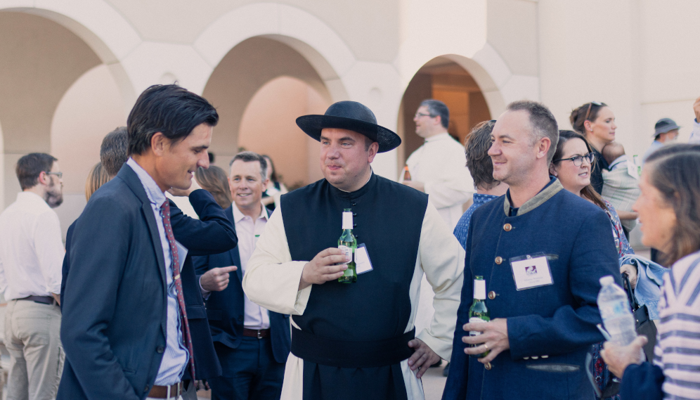 Four alumni, one a religious, chat over drinks