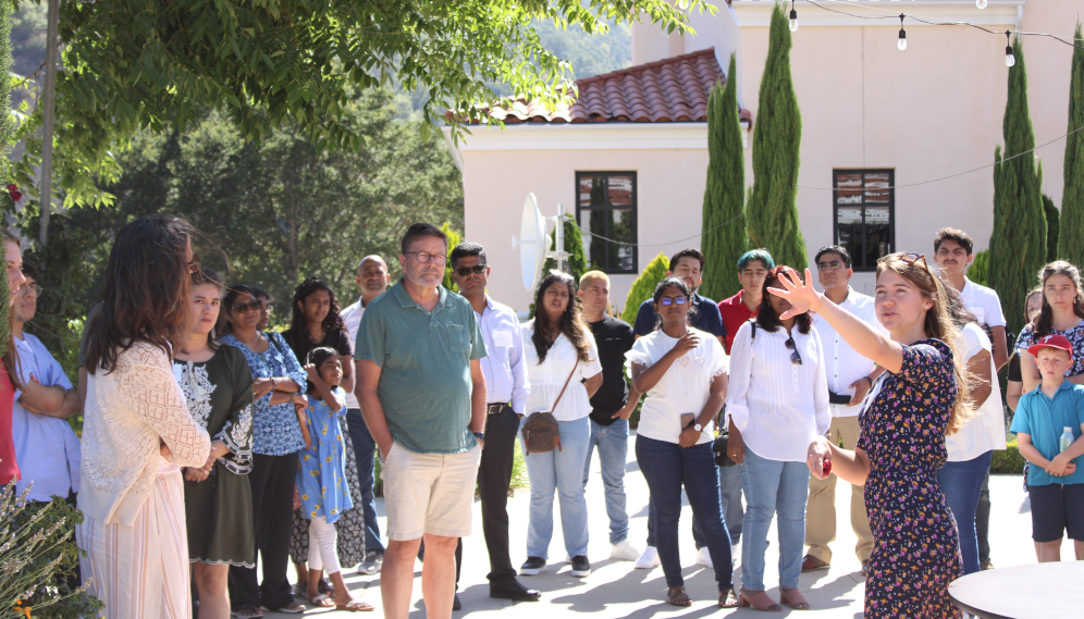 An Admissions official gives a tour of the campus to the parents on Gladys Patio