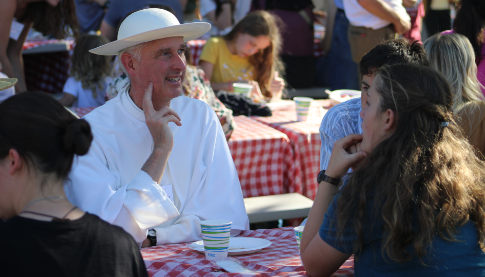 Fr. Walshe talks with students at the picnic tables