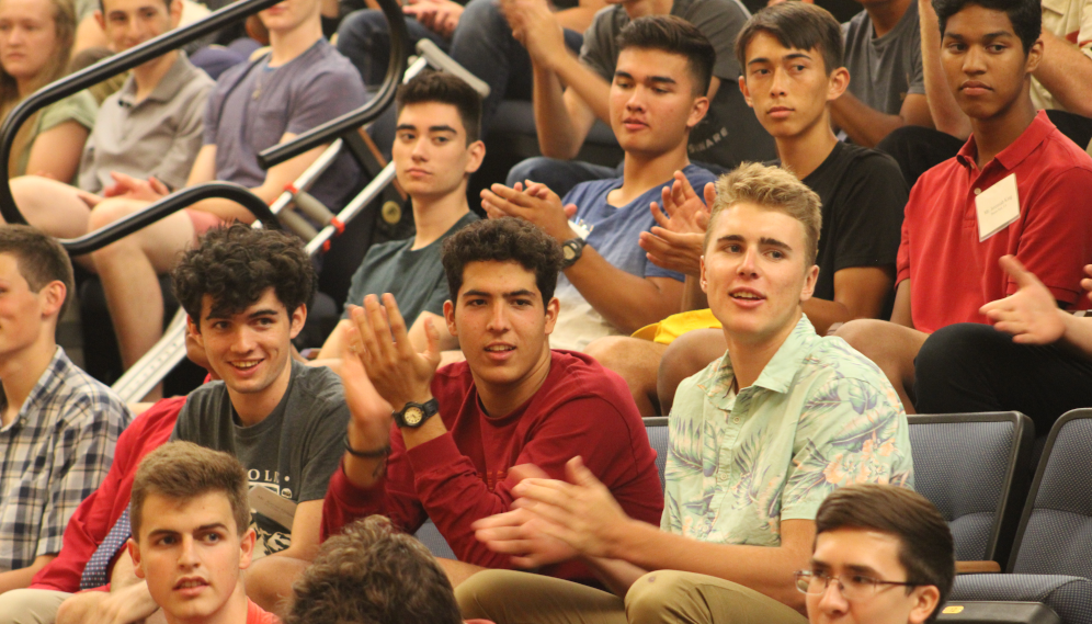 Students seated in the auditorium applaud