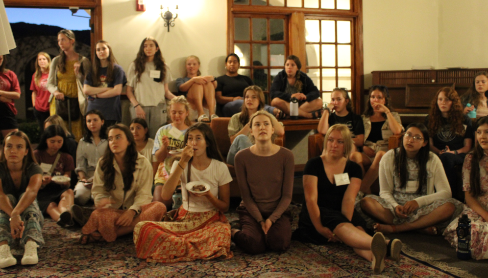In the women's dorm, students gather 'round for an address from the prefects
