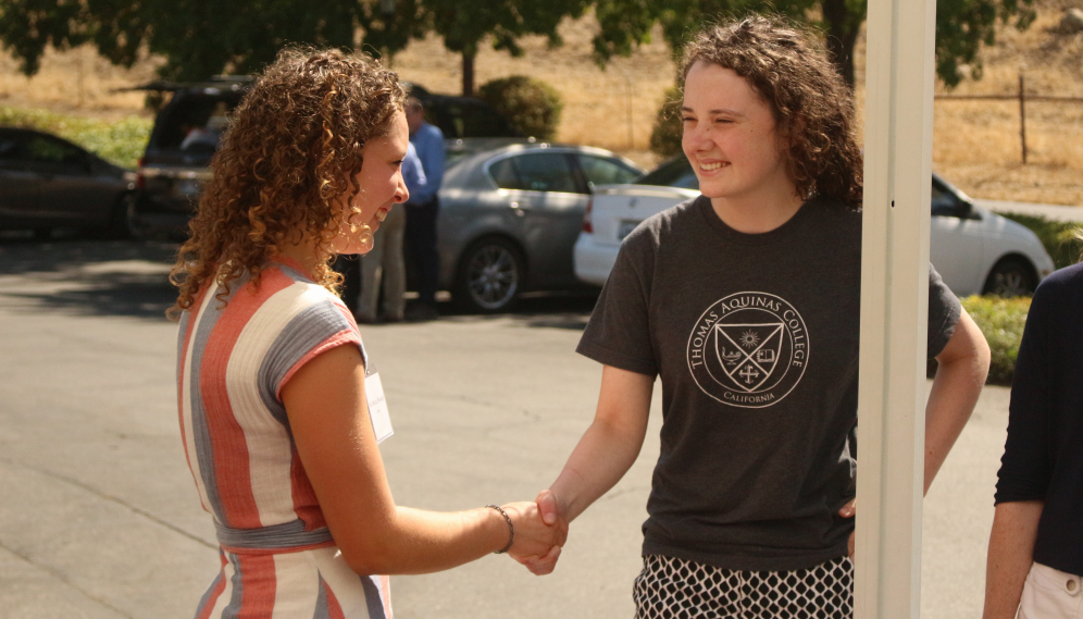 An Admissions member greets a freshman