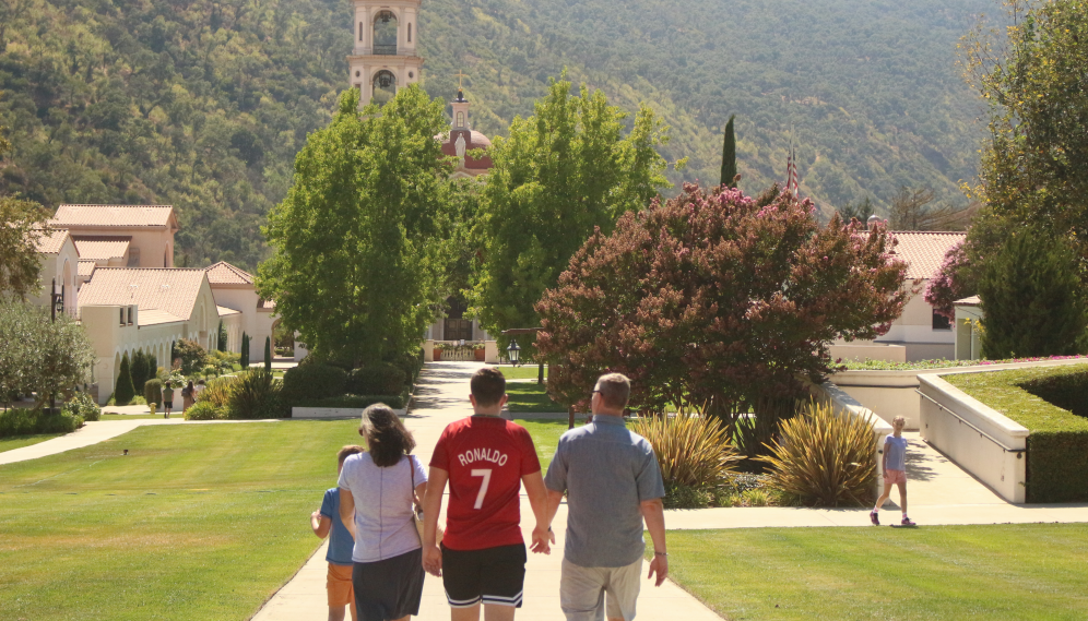 A freshman walks toward the Chapel with their family