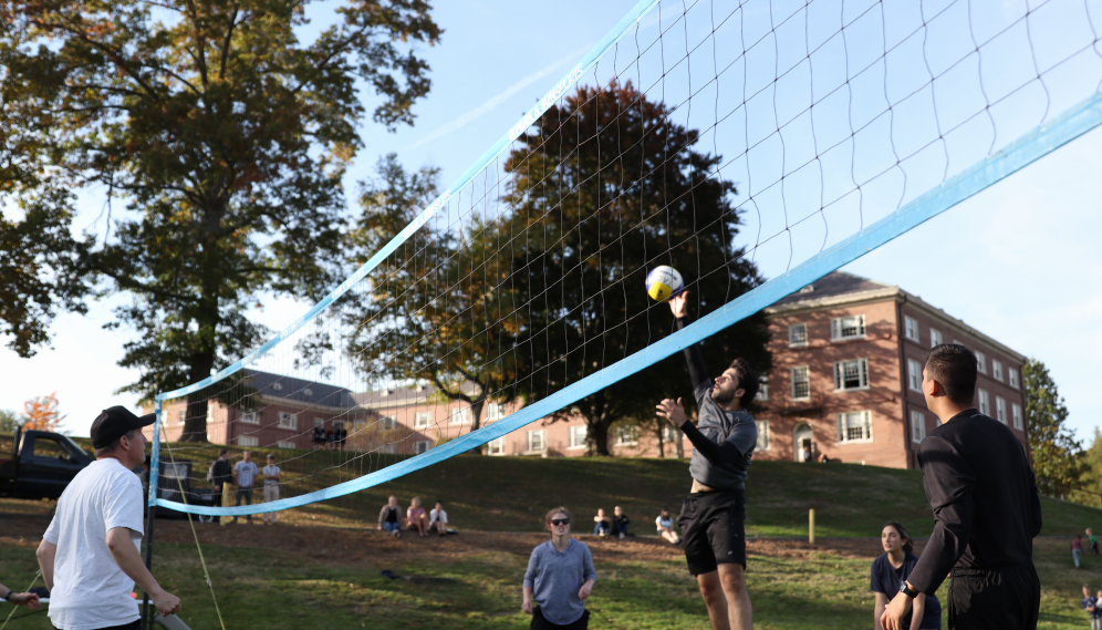 A student sends the ball over the net