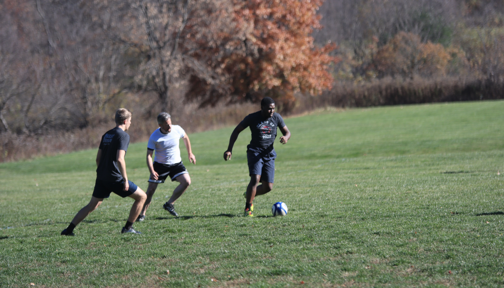 A student with the ball evades an opponent