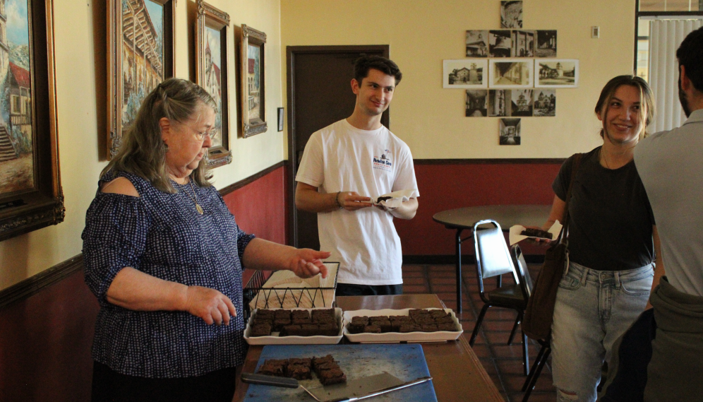Students chat around the brownie table