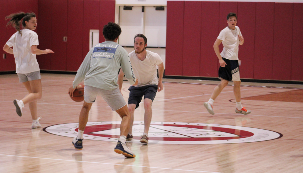 Students compete for the ball at the center of the court