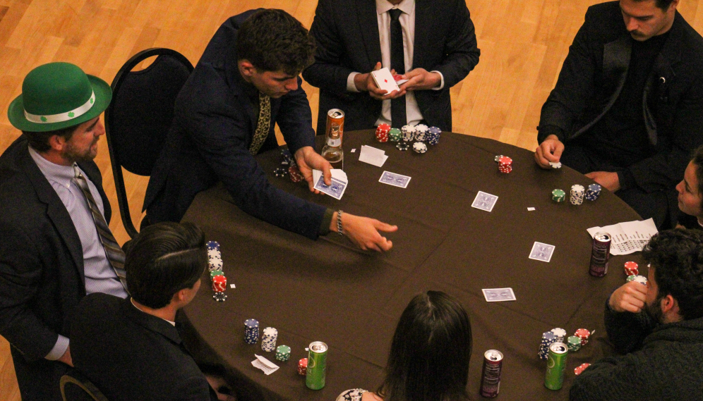 Poker players at one of the tables with Dr. Cooper in a green hat