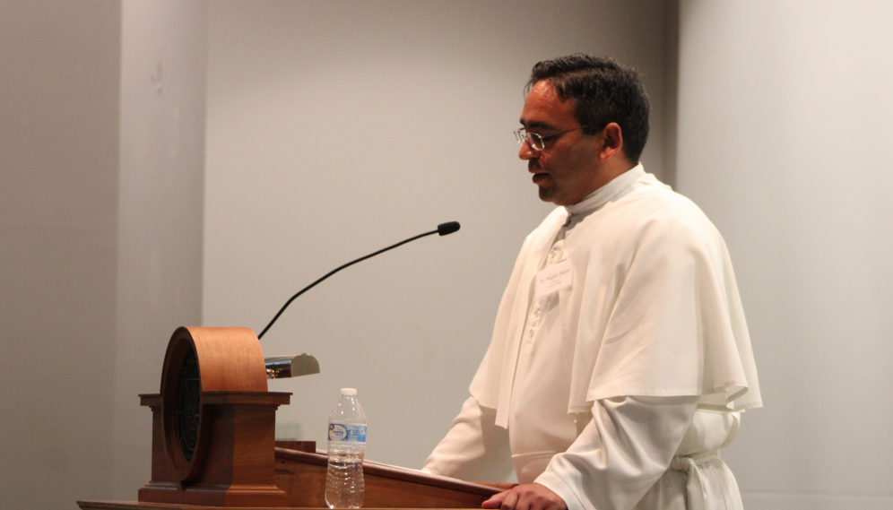 Fr. Miguel speaks at the podium