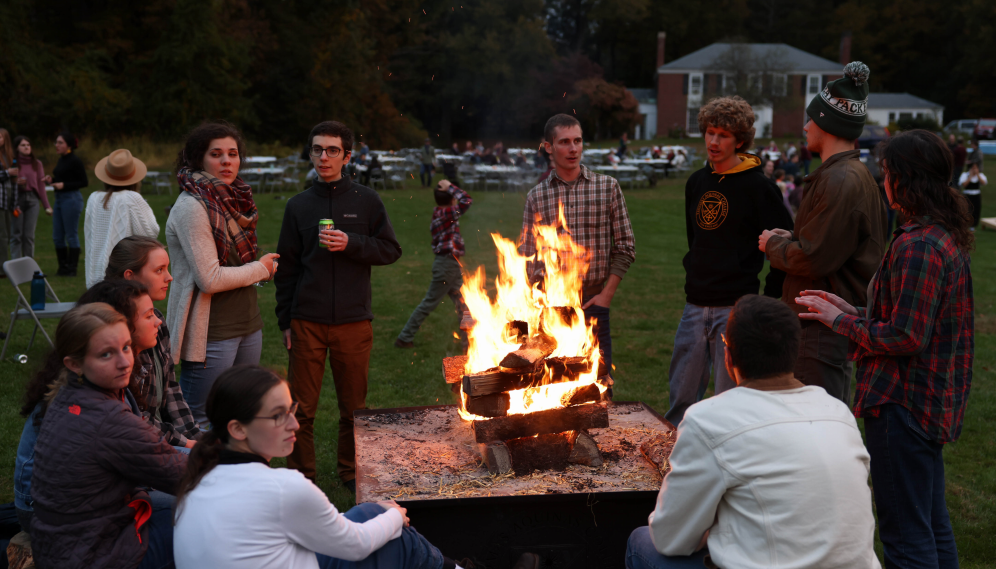 members of various classes gather around for a bonfire