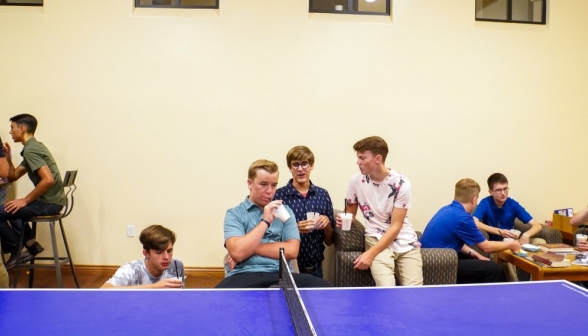 Students enjoy their drinks behind the ping-pong table