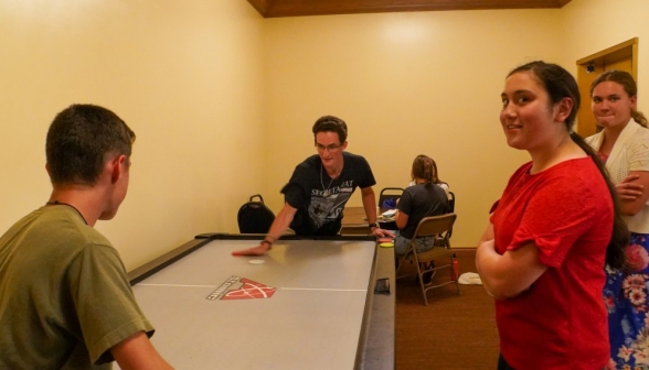 Students play air hockey with their bare hands
