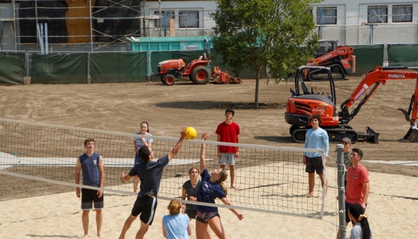 The volleyball game: both sides contesting the ball, right above the net!