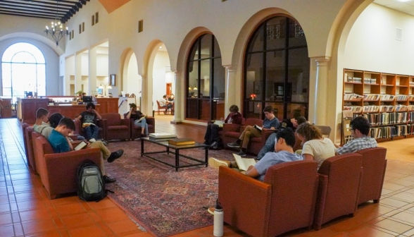 Students fill the armchairs in the central hall of the library