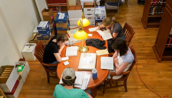Overhead shot of four students working at one of the tables