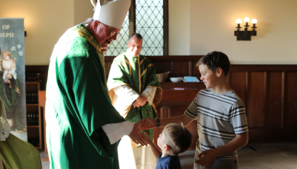 Bishop Byrne shakes hands with two children