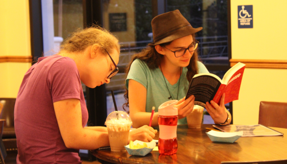 Two students study at a coffee shop table