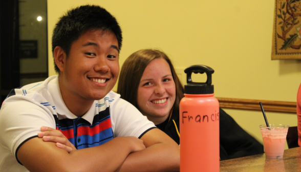 Two students pose behind a water bottle