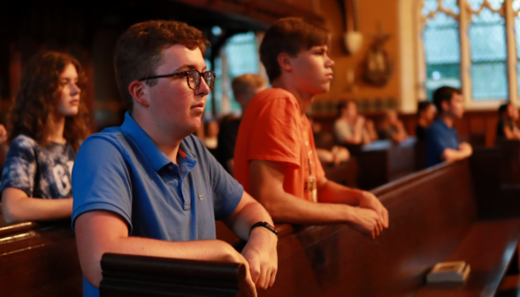 Students praying in a pew