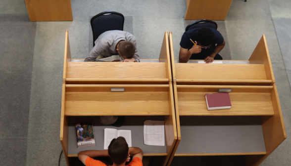 Three studying at individual desks