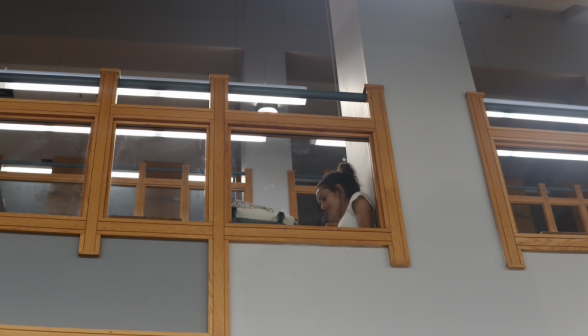 A student studies by the railing, overlooking the lower floor