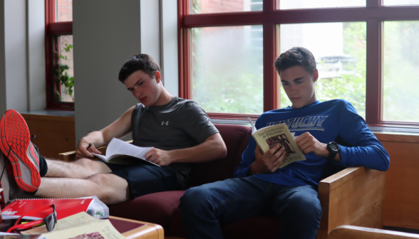 Two read Boethius on a couch