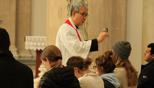 Fr. Chung blesses students with the relic