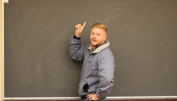 A student in front of a blackboard points to "A+B" written on it