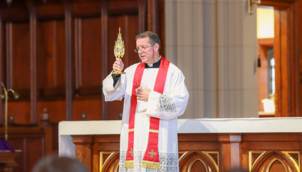 Fr. Markey holds up the relic