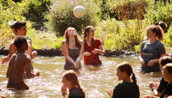 In the pond, a student sets a volleyball