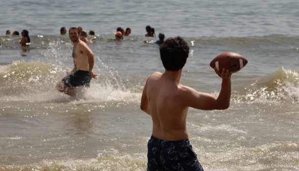 Students pass a football in the water