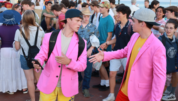 Two men in hot pink sports jackets chat