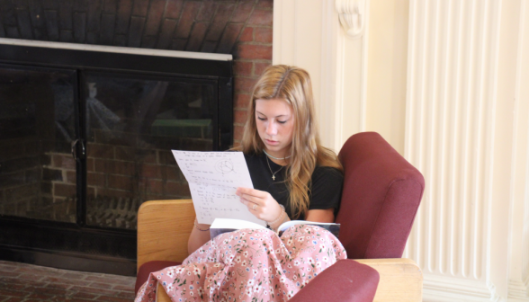 A student studies by the fireplace