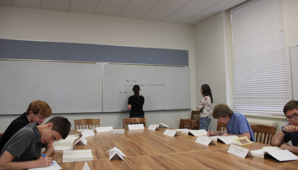Long shot of students studying at the table and the board