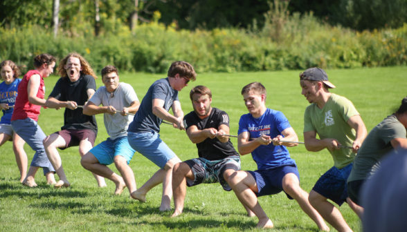 A group of young men playing tug of war.