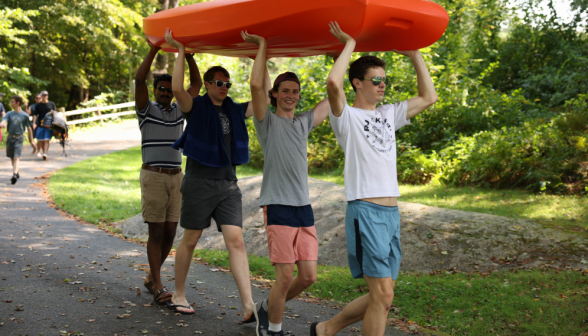 The boys carry a kayak